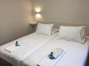 a white bed with two towels and two bottles on it at Segal in Jerusalem Apartments in Jerusalem