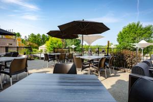a patio with tables and chairs and umbrellas at Estrimont in Magog-Orford