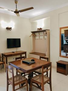 a dining room with a table and chairs and a tv at Lafala Hotel & Service Apartment in Colombo