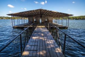 a wooden dock with a building on the water at Point View Resort in Camdenton