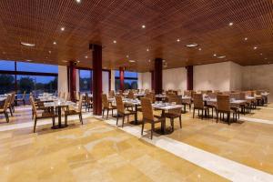 Un gran comedor con mesas y sillas. en Exe Layos Golf, en Layos