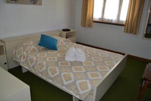 a bedroom with a bed with two shoes on it at Apartamento Foz do Rio Minho in Caminha