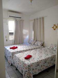 Duas camas num quarto com almofadas vermelhas em Apt Candeias para 6 pessoas no Recife