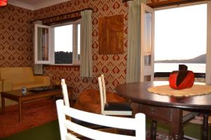 sala de estar con mesa, sillas y ventanas en Apartamento Foz do Rio Minho en Caminha