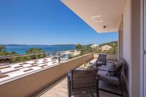 einen Balkon mit Stühlen, einem Tisch und Meerblick in der Unterkunft Villa Gellia in Ugljan