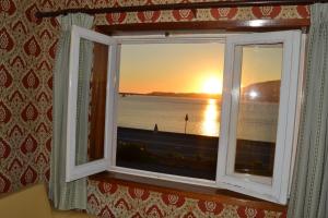 a window with a view of the sunset at Apartamento Foz do Rio Minho in Caminha +2 photos