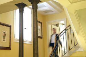 Un uomo che scende le scale in una casa di Corte Barozzi Venice Suites a Venezia