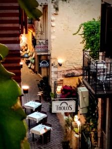 a narrow street with tables and a sign that readsudos at Palazzo di Pietro in Chania