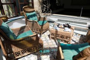 eine Terrasse mit Korbstühlen und einem Tisch mit Teekanne in der Unterkunft Chambres d'Hôtes Justin de Provence in Orange