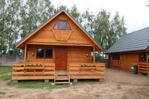 eine große Holzhütte mit einer Veranda und einem Fenster in der Unterkunft Domki kempingowe Moto Przystań in Brochów