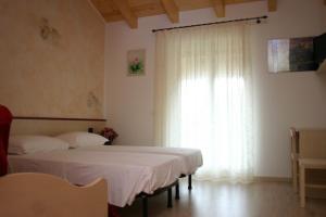 1 Schlafzimmer mit 2 Betten und einem großen Fenster in der Unterkunft Agritur Due Valli in Livo