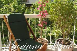 a green chair sitting on a balcony with flowers at Mariu Apartment in Buenos Aires