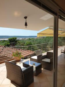 eine Terrasse mit einem Tisch und Stühlen sowie Aussicht in der Unterkunft Rooms & Apartments Giulia in Portorož