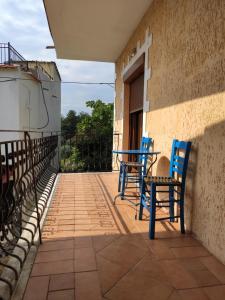 a balcony with two blue chairs and a table at Elpida Apartment in Limenas
