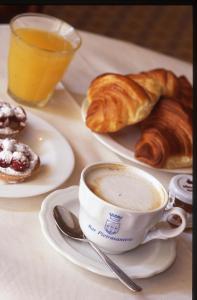 a table with plates of pastries and a cup of coffee at Locanda Pietrasantese B&B in Pietrasanta