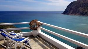 two chairs and a vase on a balcony overlooking the ocean at Agia Kyriaki Studios in Agia Kiriaki Beach