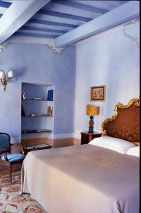 a blue bedroom with a bed and a chair at Locanda Pietrasantese B&B in Pietrasanta