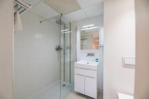 a white bathroom with a shower and a sink at Boutique hôtel Maria-Christina in Saint-Jean-de-Luz +103 photos