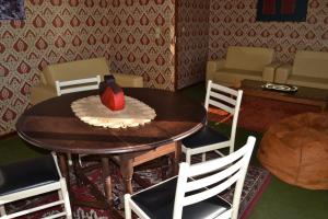 una mesa de comedor con sillas y una botella de vino en Apartamento Foz do Rio Minho en Caminha