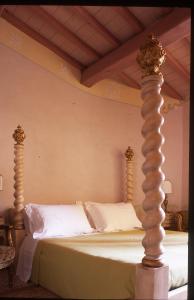 a bed with two posts in a bedroom at Locanda Pietrasantese B&B in Pietrasanta