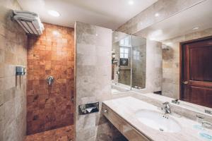 
a bathroom with a tub, sink, mirror and shower at Iberostar Tucan in Playa del Carmen
