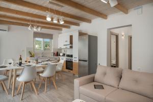 a living room and kitchen with a table and a couch at b&m villas in Metókhion Sirilíou