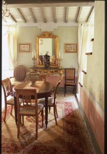 una sala da pranzo con tavolo, sedie e specchio di Locanda Pietrasantese B&B a Pietrasanta