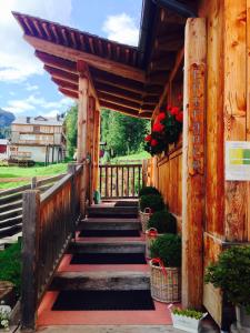 eine Treppe, die zu einem Holzgebäude mit Blumen führt in der Unterkunft Residence Valpiccola in Val di Zoldo