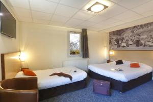 um quarto de hotel com duas camas e uma cadeira em Logis Relais Des Puys em Orcines