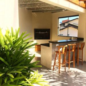 une cuisine avec un bar avec des tabourets et quelques plantes dans l'établissement Pousada Pedra Rosa, à Florianópolis