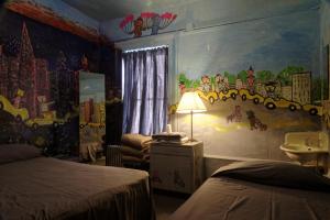Un pat sau paturi într-o cameră la Carlton Arms Hotel