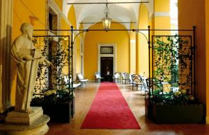 a statue of a man in a hallway with a red carpet at Palazzo Cardinal Cesi in Rome