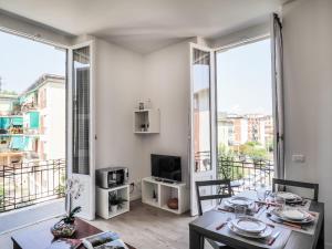 een woonkamer met een tafel en stoelen en grote ramen bij Le case sul parco in La Spezia