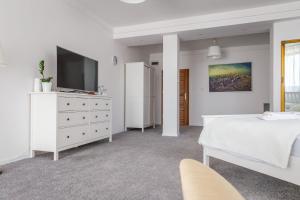 库特诺Siódme Niebo的一间带床和电视的白色卧室