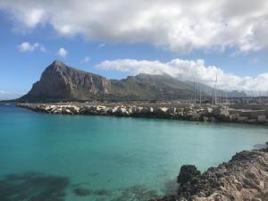 a body of water with a mountain in the background at B&b IL FIOCCO E LA RANDA in San Vito lo Capo +21 photos