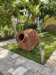 a large brown vase sitting in the grass at Elpida Apartment in Limenas