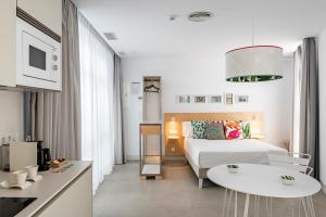 a hotel room with a bed and a table and a kitchen at Apartamentos y estudios céntricos Conil Home Suite in Conil de la Frontera