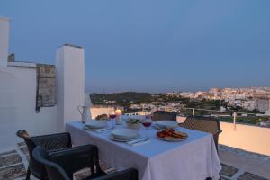 stół z jedzeniem i winem na balkonie w obiekcie Palazzo Le Cupole by Wonderful Italy w mieście Ostuni