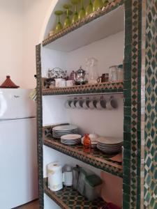 estanterías de cocina con platos y utensilios en Dar es Salam-Baja en Asilah