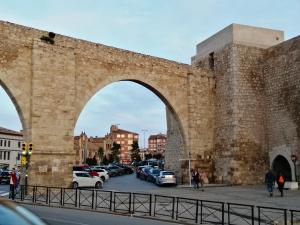 un vieux pont en pierre avec des voitures garées dans un parking dans l'établissement Estudio-apartamento Cancún, à Teruel