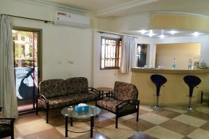 
a living room filled with furniture and a tv at Petit Motel Beijing in Abidjan
