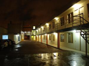 una calle vacía por la noche con edificios iluminados en Posada San José, Hotel, en Puebla