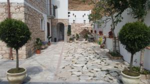 an alley with potted trees and a building at Hotel Goloritzé in Baunei