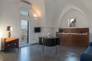 a living room with a table and a kitchen at Palazzo Le Cupole by Wonderful Italy in Ostuni