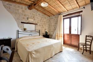 a bedroom with a bed and a large window at Hotel Goloritzé in Baunei