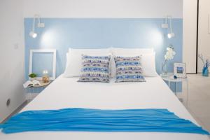 托雷斯港的住宿－Il Pescatore di Sogni，一张白色的大床,配有蓝色和白色的枕头