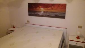 a small bedroom with a bed and a painting on the wall at Villa del Palmeto in Badesi