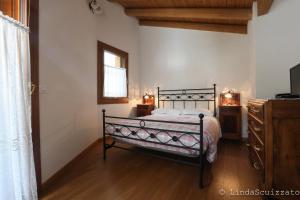 1 dormitorio con 1 cama, vestidor y ventana en Il Capriolo Felice - Agriturismo en Lastebasse