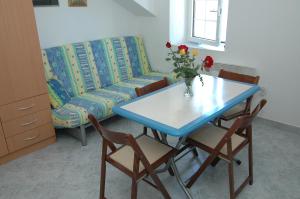 ein Wohnzimmer mit einem Tisch und einem Sofa in der Unterkunft Bujanic Apartments in Tivat