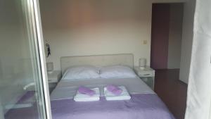 a bed with purple and white pillows and a mirror at Apartments Lena in Sutomišćica